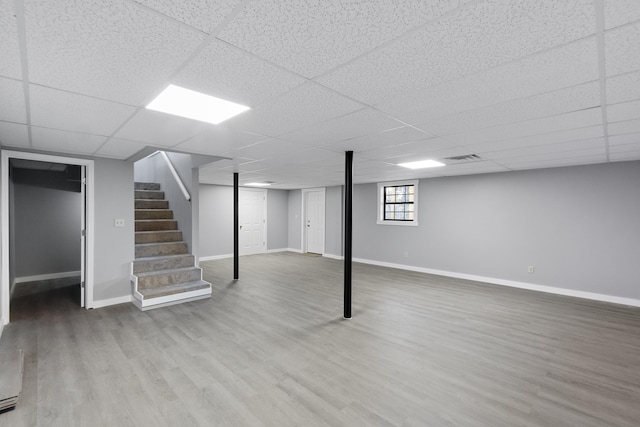 basement featuring hardwood / wood-style flooring and a paneled ceiling