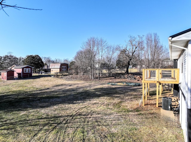 view of yard featuring a storage shed and central AC unit