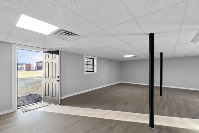 basement with dark wood-type flooring and a drop ceiling