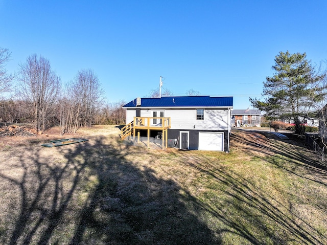 rear view of house featuring a wooden deck and a lawn