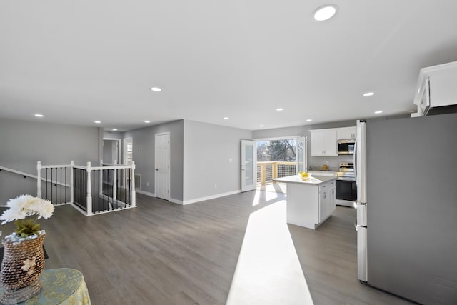 kitchen featuring white cabinetry, dark hardwood / wood-style floors, stainless steel appliances, and a center island