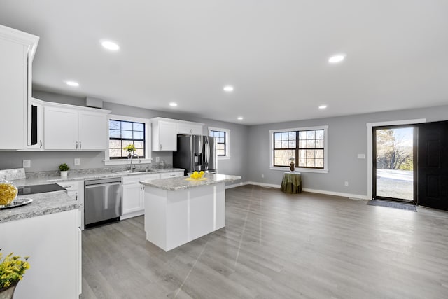 kitchen featuring appliances with stainless steel finishes, a center island, sink, and white cabinets