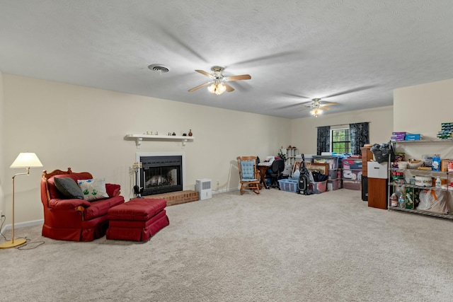 961 Woodway Dr, Morristown, TN 37814 - carpeted living area with visible vents, a ceiling fan, a fireplace with raised hearth, and a textured ceiling