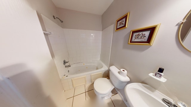 bathroom featuring tile patterned flooring, tiled shower / bath combo, and toilet