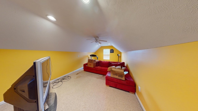 interior space with a textured ceiling, ceiling fan, carpet, and lofted ceiling