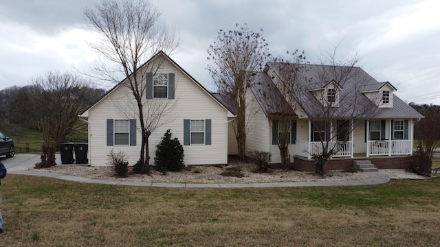 cape cod-style house with covered porch and a front lawn