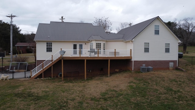 rear view of house with cooling unit, a yard, a wooden deck, and french doors