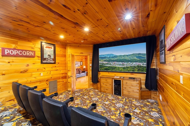 carpeted home theater room featuring wood walls and wood ceiling