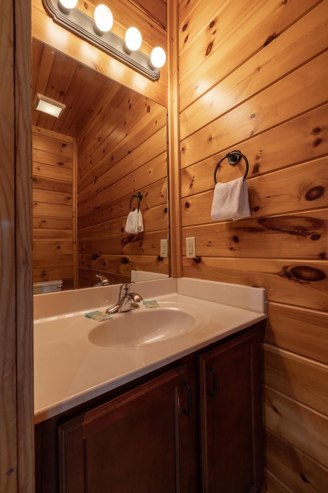 bathroom with wood walls and vanity