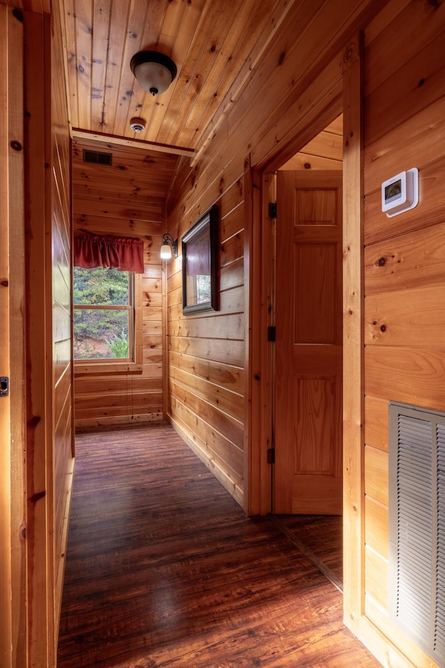 hallway featuring dark hardwood / wood-style floors, wooden ceiling, and wooden walls