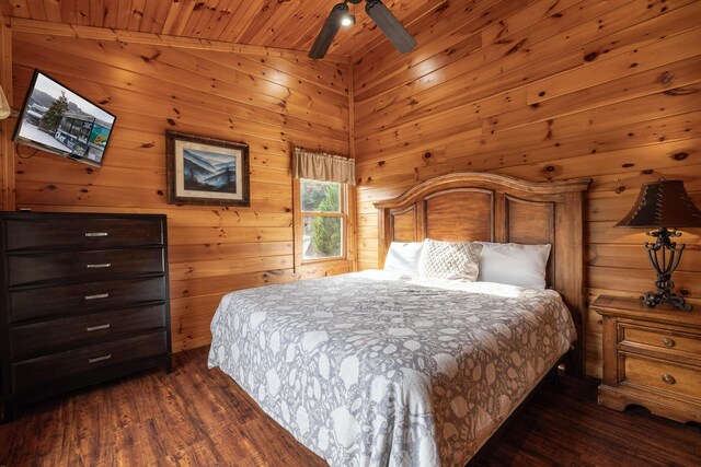 bedroom featuring vaulted ceiling, ceiling fan, wooden ceiling, dark hardwood / wood-style floors, and wood walls