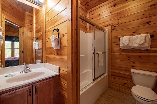 full bathroom with tile patterned floors, vanity, wooden walls, wooden ceiling, and toilet