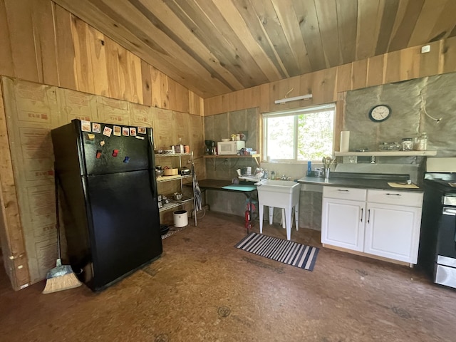 4750 Laws Rd, Del Rio, TN 37727 - kitchen featuring freestanding refrigerator, lofted ceiling, dark countertops, wood walls, and stainless steel electric range oven