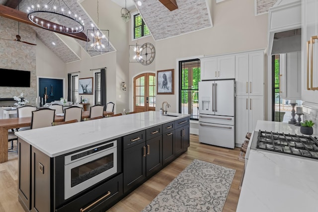 1670 Bays Mountain Rd, New Market, TN 37820 - kitchen with a sink, high vaulted ceiling, white fridge with ice dispenser, white cabinetry, and built in microwave