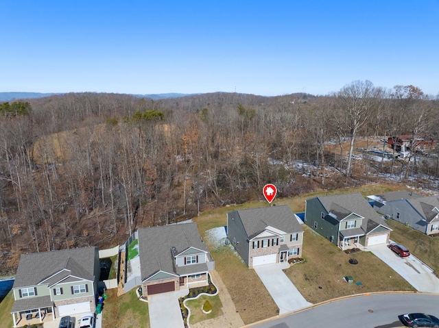 drone / aerial view featuring a residential view and a view of trees