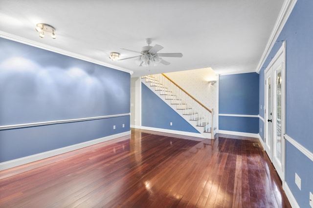 empty room featuring crown molding, stairway, hardwood / wood-style floors, a ceiling fan, and baseboards