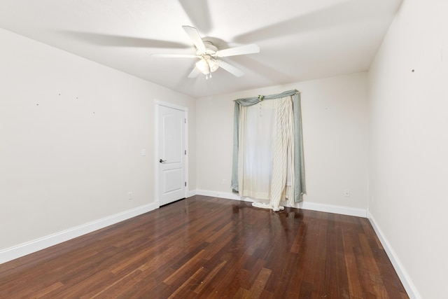 empty room featuring ceiling fan, baseboards, and wood finished floors