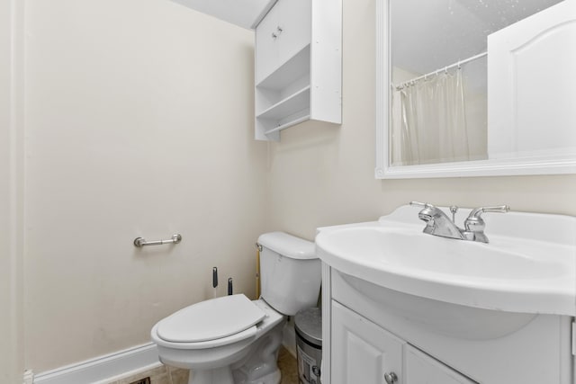 full bath featuring vanity, toilet, and baseboards