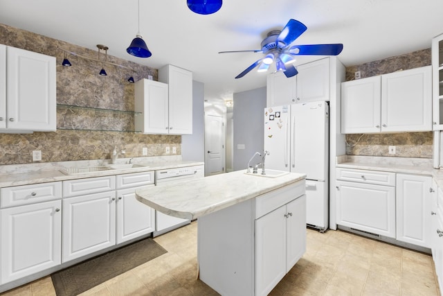 kitchen with white appliances, a sink, and white cabinets