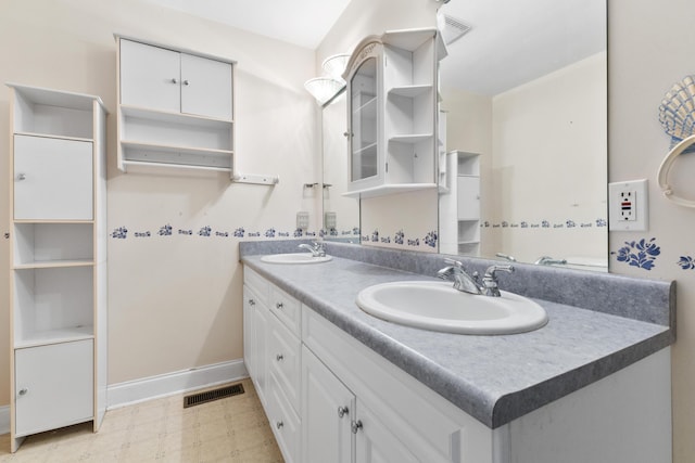 bathroom featuring baseboards, a sink, visible vents, and tile patterned floors