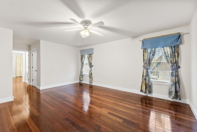 empty room featuring visible vents, baseboards, ceiling fan, and hardwood / wood-style floors