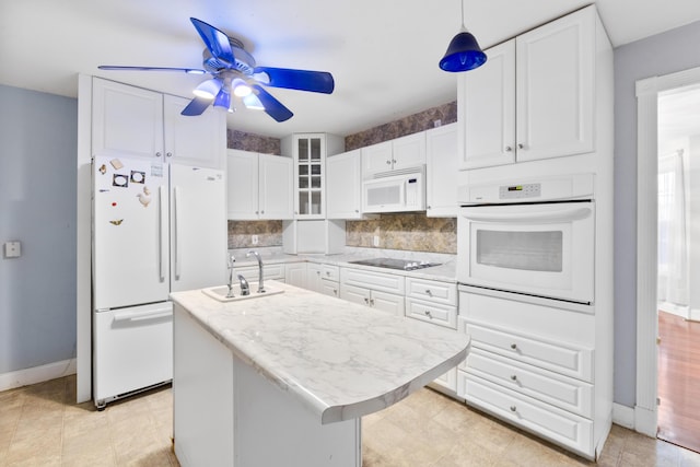 kitchen with white appliances, light countertops, a sink, and white cabinetry