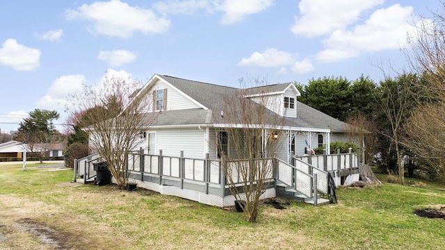 exterior space featuring roof with shingles, a lawn, and a wooden deck