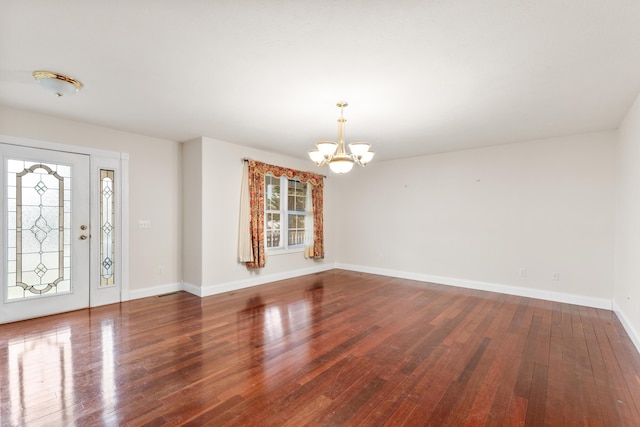 entrance foyer with baseboards, wood finished floors, and a notable chandelier