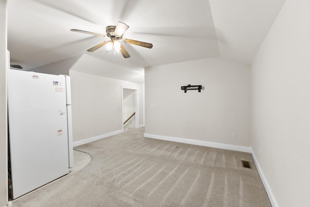 interior space with carpet floors, lofted ceiling, visible vents, a ceiling fan, and baseboards