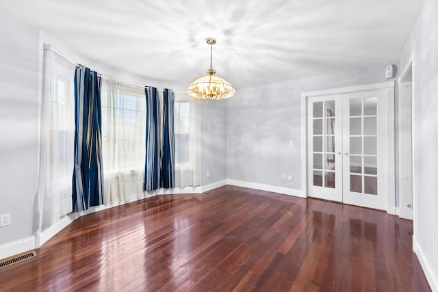 spare room with wood-type flooring, visible vents, a notable chandelier, and french doors