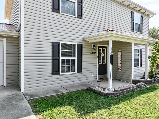 property entrance featuring a porch and a lawn