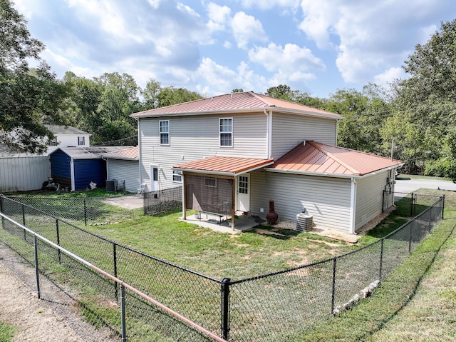 rear view of house with central AC unit, a yard, and a patio