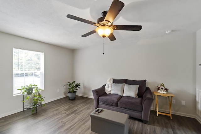 living room featuring ceiling fan and dark hardwood / wood-style flooring