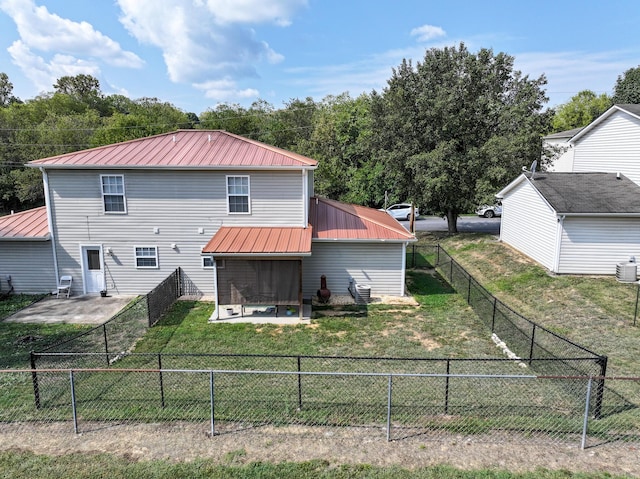 back of house with a lawn and a patio