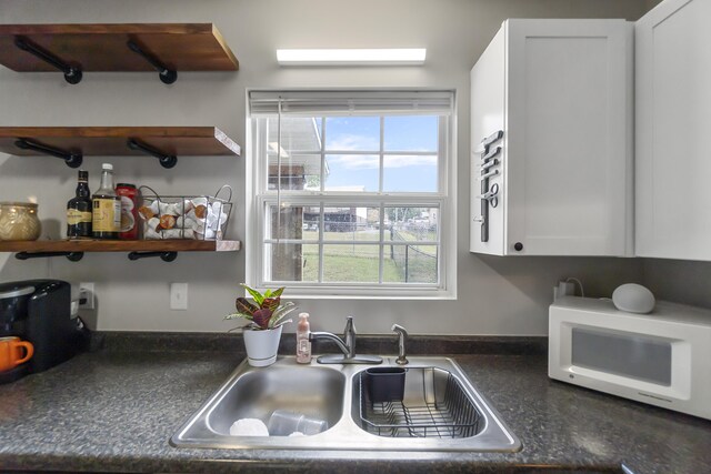 kitchen featuring white cabinetry and sink