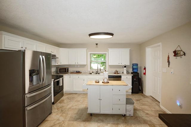 2368 Hall Rd, Dandridge, TN 37725 - kitchen featuring stainless steel appliances, white cabinetry, under cabinet range hood, a center island, and light stone finish floors