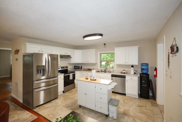2368 Hall Rd, Dandridge, TN 37725 - kitchen with stainless steel appliances, under cabinet range hood, light countertops, and white cabinets