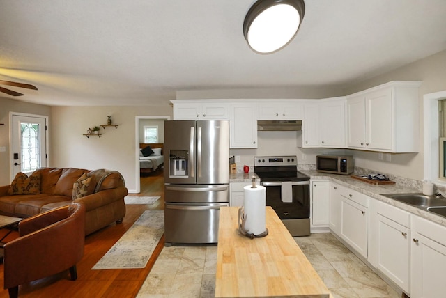 2368 Hall Rd, Dandridge, TN 37725 - kitchen featuring appliances with stainless steel finishes, open floor plan, under cabinet range hood, ceiling fan, and white cabinets