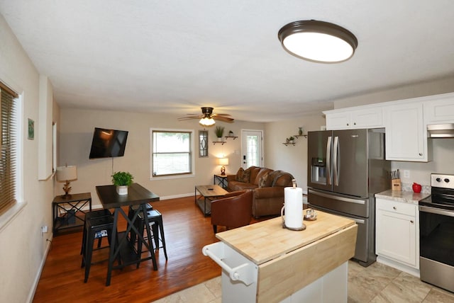 2368 Hall Rd, Dandridge, TN 37725 - kitchen featuring appliances with stainless steel finishes, under cabinet range hood, white cabinetry, a center island, and a ceiling fan