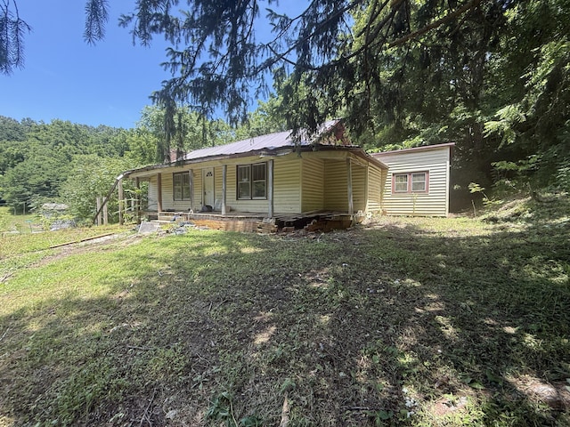 1340 Ryan Rd, Fall Branch, TN 37656 - view of front of house featuring covered porch, a front yard, a metal roof, and a view of trees