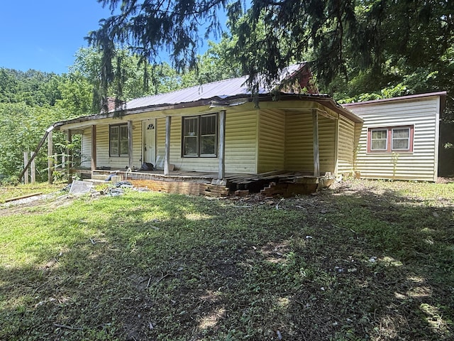 1340 Ryan Rd, Fall Branch, TN 37656 - view of front of house featuring covered porch, a metal roof, a front lawn, and faux log siding