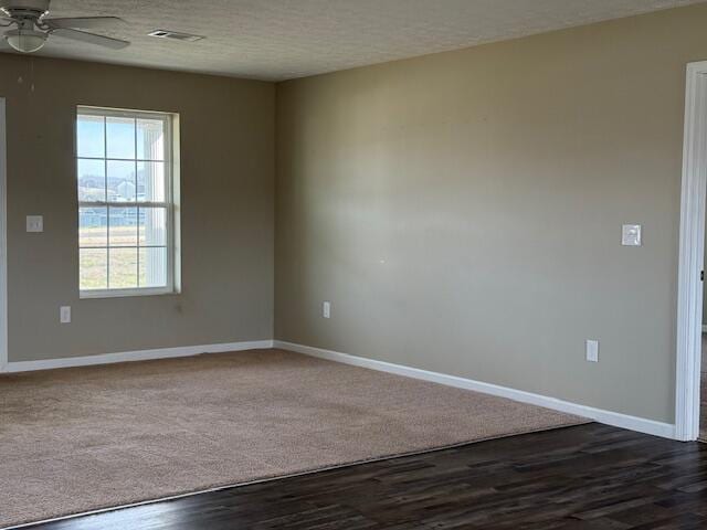 unfurnished room with visible vents, baseboards, a textured ceiling, and ceiling fan