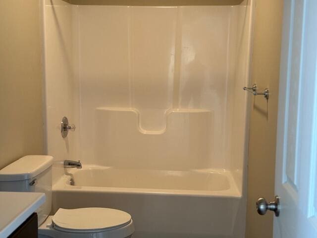 full bath featuring washtub / shower combination, toilet, and vanity