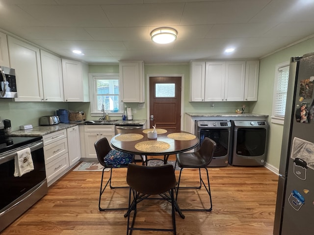 3207 Dove Ln, White Pine, TN 37890 - kitchen featuring appliances with stainless steel finishes, washer and clothes dryer, white cabinetry, and light wood finished floors