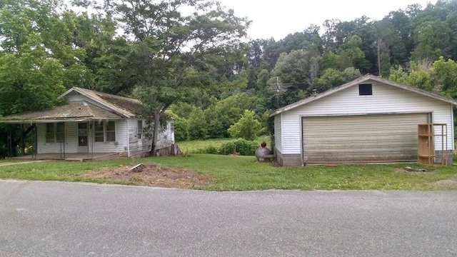 garage with a porch and a lawn