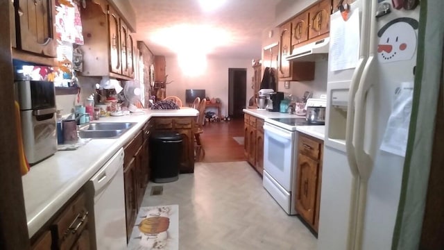 kitchen featuring kitchen peninsula, white appliances, and sink