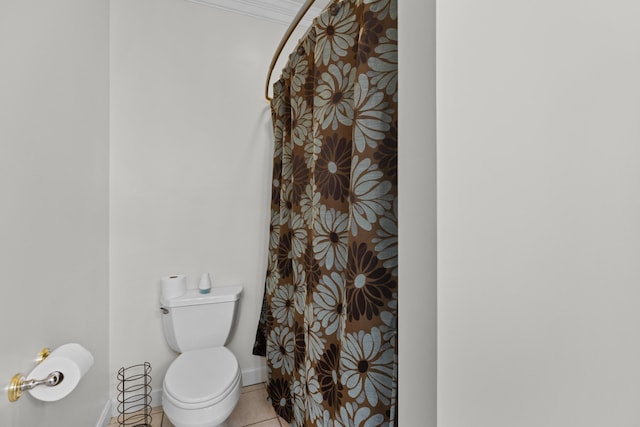 bathroom featuring tile patterned flooring, toilet, and crown molding