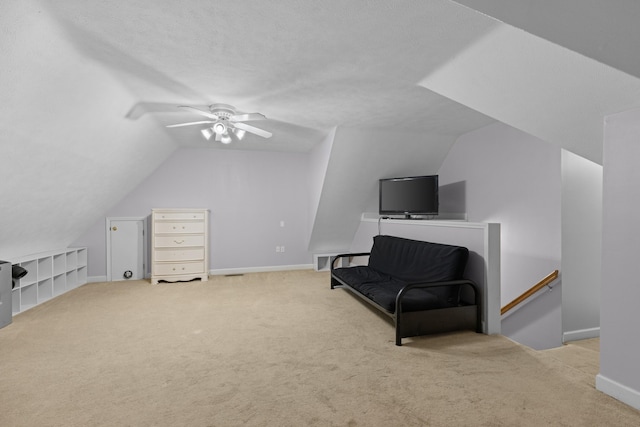 sitting room with a textured ceiling, ceiling fan, light carpet, and lofted ceiling