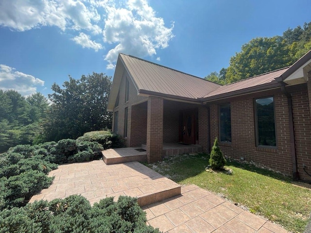 view of side of property featuring a lawn and a patio area