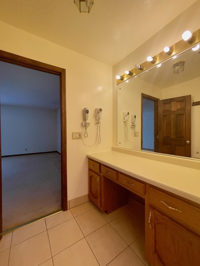 bathroom with a textured ceiling, vanity, and tile patterned floors